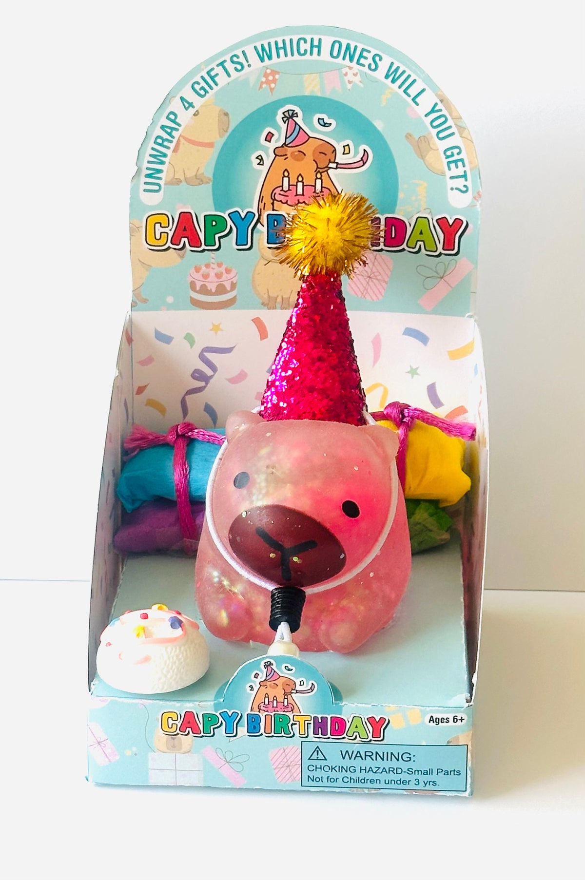 Zorbitz Capy Birthday capybara squishy toy in its boxed packaging, sparkly pink capybara in a glitter party hat with mini cake and wrapped surprise gifts