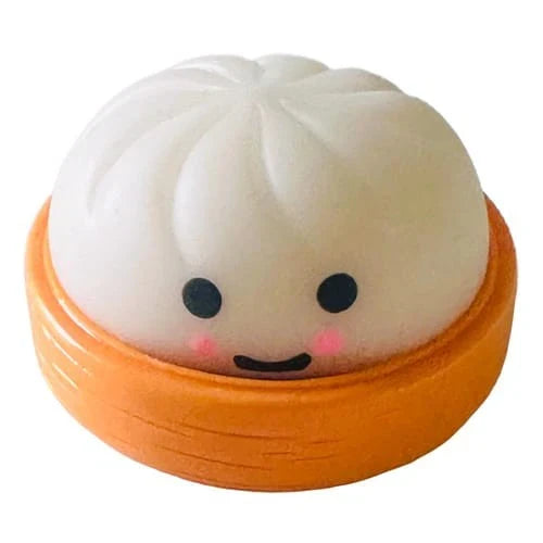 White smiling mini dumpling squishy sitting in an orange steamer basket case