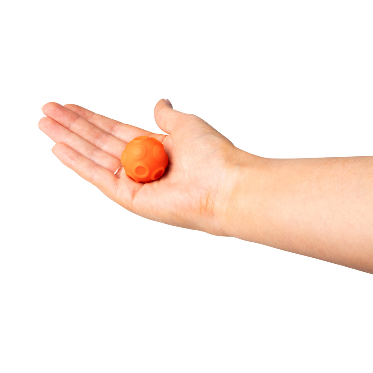 All four magnetic sensory spheres in pink, orange, green, and purple held together in one hand