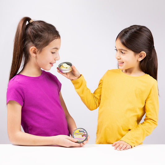 Child smelling Banana Split SCENTsory Thinking Putty while another child holds the collectible tin.