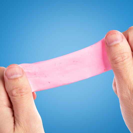 Hands stretching Mini Strawberry Shortcake SCENTsory Thinking Putty showing its soft, stretchy texture.