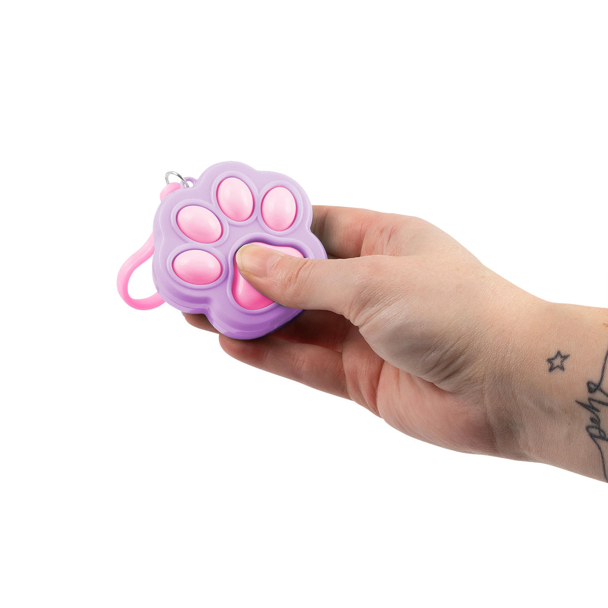 Hand holding two Fidget Paw Clicker Keychains, one pink and purple and one white and pink
