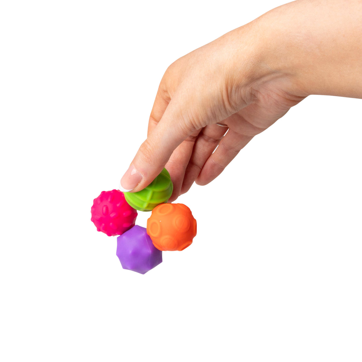 Close-up of fingers pinching the pink bumpy textured magnetic sensory sphere