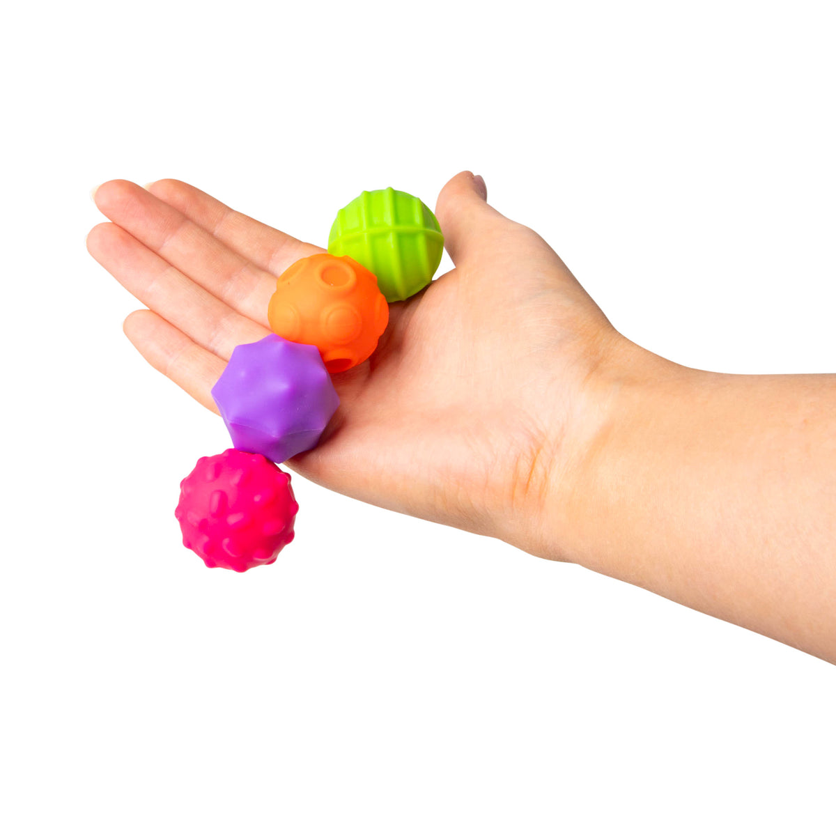 Hand holding a vertical stack of purple, orange, green, and pink magnetic sensory spheres