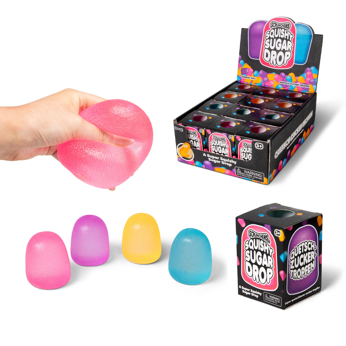Hand squeezing a pink Squishy Sugar Drop toy, shown with the display box and loose gumdrop colors