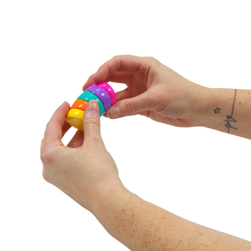 Hands twisting the Torsion Rainbow Circle fidget toy rings
